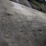 Engraved rock in Castagneto-In Vall, depictions of animals and of human figures wielding weapons